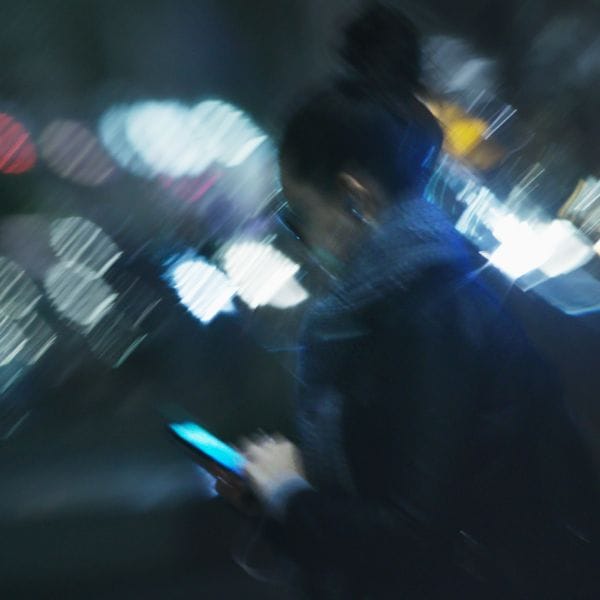 Blurred person with phone in city